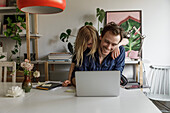 Smiling man with daughter in home office