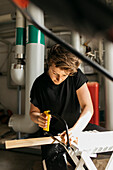 Woman sawing piece of wood