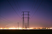 Silhouette of electricity pylon at dusk