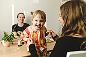 Mother with daughter sitting at table