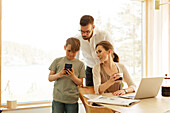 Boy using cell phone while parents watching