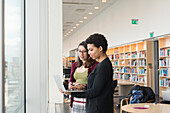 Frauen in der Bibliothek am Laptop