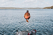 Woman jumping into sea