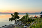 Frau mit Blick auf Sonnenuntergang am Meer