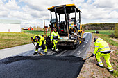 Workers putting new road surface