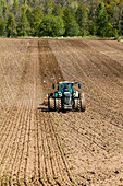 Traktor beim Eggen eines Feldes