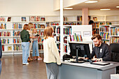 Mädchen im Gespräch mit Bibliothekarin in der Bibliothek