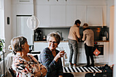 Senior friends talking together in kitchen