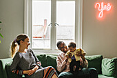 Parents with baby girl sitting on sofa