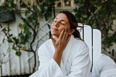 Smiling woman applying face cream