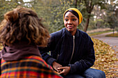 Frau im Gespräch mit einem Freund im Park