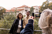 Woman taking picture of female friends by cell phone