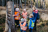 Playschool teachers with children in forest