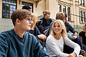 Teenagers talking together in front of school