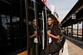 Junge Frau steigt in Bus ein