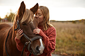 Woman stroking horse in farm