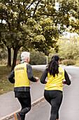 Sehbehinderte Frau joggt mit Guide