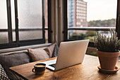 Laptop and cup of coffee on table