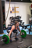 Frau beim Gewichtheben im Fitnessstudio