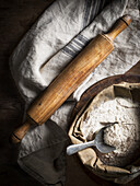 High angle view of flour and wooden rolling pin