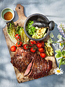 Meat and grilled vegetables on chopping board
