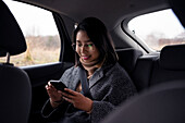 Woman with mobile phone in car