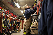 Feuerwehrfrau beim Umkleiden in einem Spind