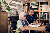Ältere Frau und Betreuerin mit Laptop