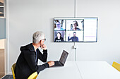 Man in boardroom having video conference
