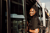 Young woman entering bus