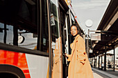 Young woman entering bus