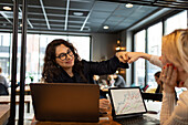 Female coworkers doing fist bump