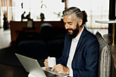 Businessman using laptop in cafe