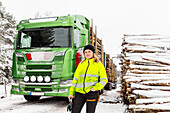 Smiling woman standing in front of lorry