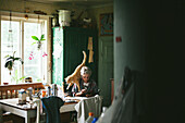Ältere Frau sitzt am Tisch