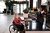 Woman on wheelchair talking to receptionist