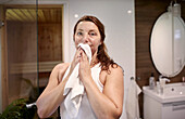 Frau trocknet ihr Gesicht im Badezimmer