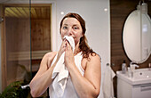 Woman drying her face in bathroom