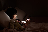 Mädchen im Bett mit Mobiltelefon