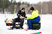 Men ice fishing in frozen lake