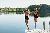 Frauen, die vom Deck in den See springen