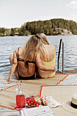 Female couple in swimsuits sitting at lake