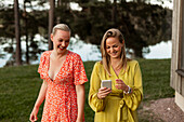 Lächelnde Freundinnen benutzen ein Smartphone