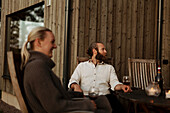 Friends sitting on porch and drinking wine