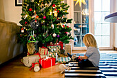 Girl sitting in front of Christmas tree