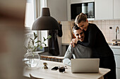 Couple hugging in kitchen