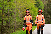 Holzfällerinnen gehen auf einem Waldweg