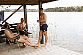 Männliche Freunde trinken Bier am See