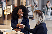 Female coworkers talking in cafe