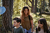 Mother with children walking through forest